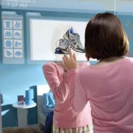 女子使用嵌在卧室壁橱门上的大型触摸屏显示器